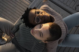 Young women leaning on each other shoulder while sitting on bench - RCPF00600