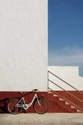 An einer Mauer geparktes Fahrrad an einem sonnigen Tag - AFVF08057