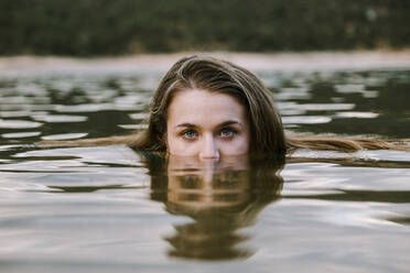 Young woman swimming in lake - MRRF00815