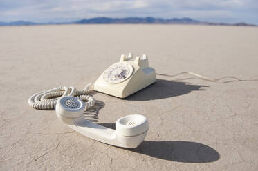 Vintage telephone on salt flat. - MINF15547