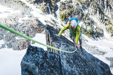 Bergsteigender Mann klettert mit Seil auf einen Berg in Washington - CAVF91738