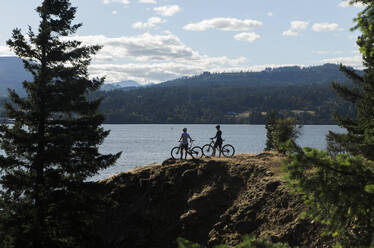 A young couple enjoy a view of the Columbia River while biking in OR. - CAVF91849
