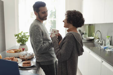 Happy couple talking in morning kitchen - CAIF30163