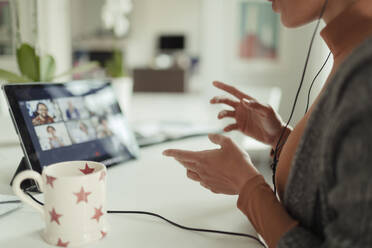 Woman video conferencing with colleagues with digital tablet at home - CAIF30169