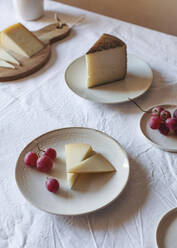 Hohe Winkel von verschiedenen schmackhaften Käse auf dem Tisch mit Anona Früchte und Trauben in der Nähe von Keramik-Krug angeordnet - ADSF20099