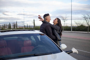 Junges Paar mit Arm um stehend durch Auto auf Straße - OCMF01989