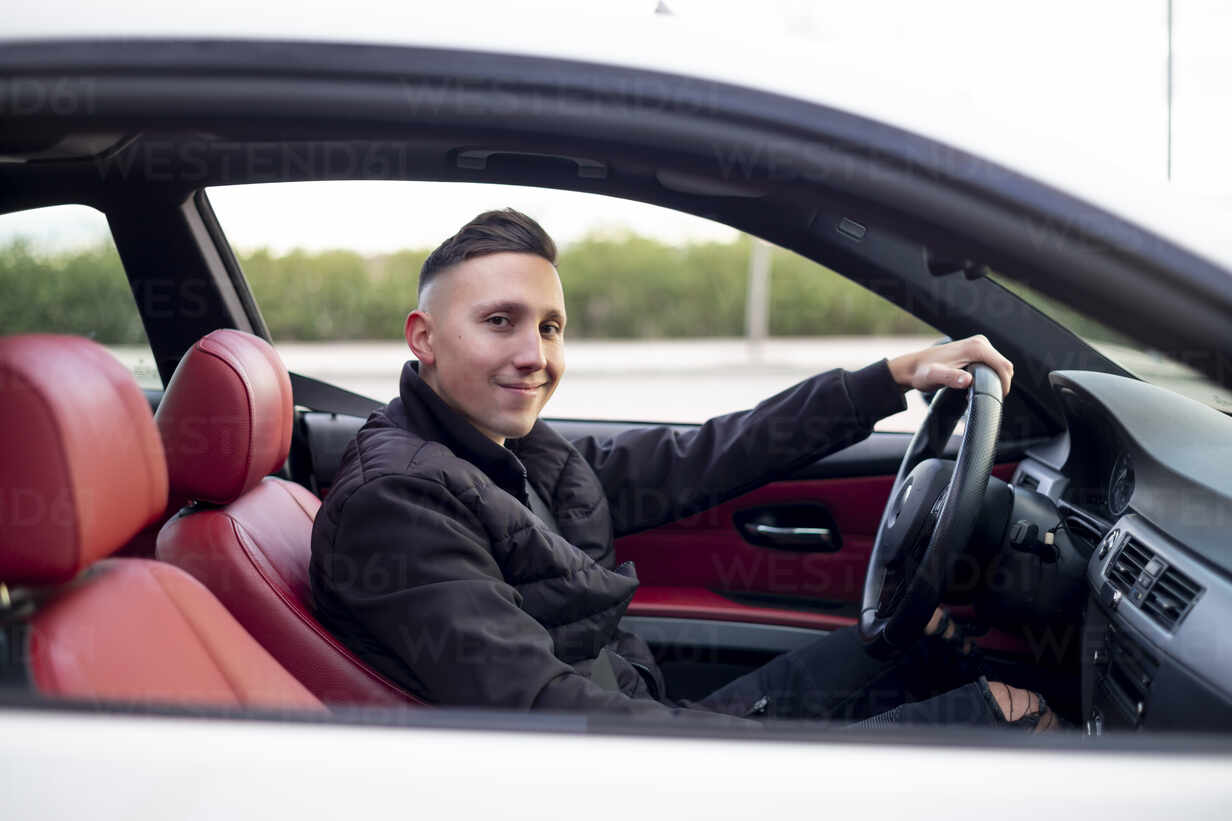 Junger Mann beim Anschnallen im Auto sitzend, lizenzfreies Stockfoto
