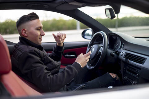 Young man using mobile phone while sitting in car stock photo