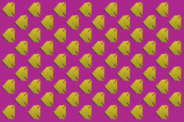 Pattern of yellow origami fish against pink background - KNTF06160