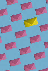 Muster aus Reihen von rosa Umschlägen mit einem einzigen gelben Umschlag - KNTF06165