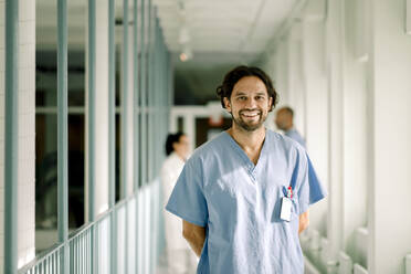 Porträt eines lächelnden Krankenpflegers auf einem Krankenhausflur - MASF21247