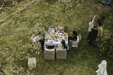 High angle portrait of smiling woman with friends enjoying in garden party - MASF21265