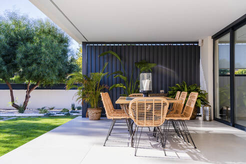 Chairs and table arranged in patio outside house - DLTSF01546