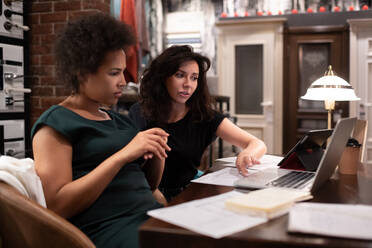 Female designers analyzing drafts on laptop - CAVF91960