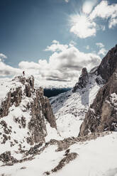 Female alpinist standing on top of snowy mountain peak enjoying view - CAVF91967