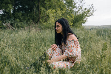 Porträt einer Frau allein auf einem Feld, die nachdenkt - CAVF91993
