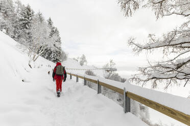 Mann wandert auf verschneitem Bergpfad - MRAF00634