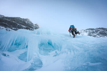 A climber free-solos a section of ice in Maine next to a parasol - CAVF92021