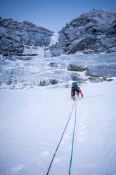 A climber ascends a steep snow section before an ice climb - CAVF92023