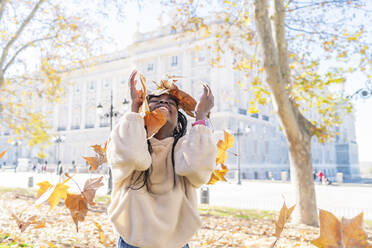 Beautiful african girl playing with leaves in the park - CAVF92030