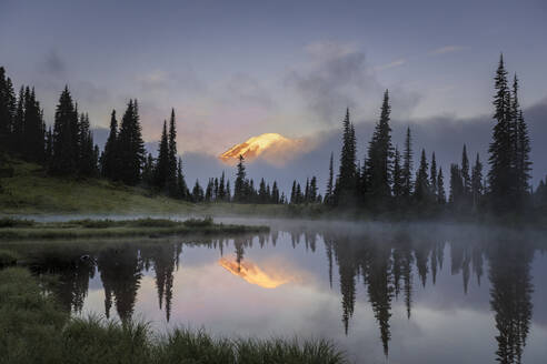 Mount Rainier peeking through the clouds during early morning sunrise - CAVF92040