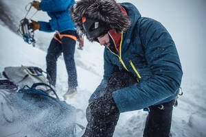 Ein Eiskletterer passt seine Stiefel vor einer Wintertour in Maine an - CAVF92067