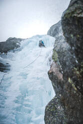 Ein Eiskletterer klettert in den Alpen von Maine eine steile Schlucht voller Eis hinauf - CAVF92073