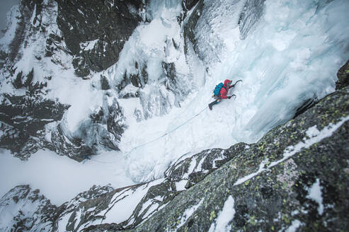 Ein alpiner Eiskletterer erklimmt eine gefrorene Schlucht in Maine - CAVF92074