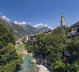 Mera River flowing amidst trees by Church of Santa Maria against sky, Valchiavenna, Chiavenna, Province of Sondrio, Lombardy, Italy - MAMF01532