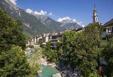 Der Fluss Mera fließt zwischen Bäumen und der Kirche Santa Maria gegen den Himmel, Valchiavenna, Chiavenna, Provinz Sondrio, Lombardei, Italien - MAMF01546