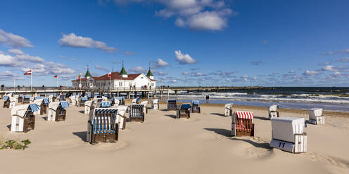 Deutschland, Mecklenburg-Vorpommern, Heringsdorf, Strandkörbe mit Kapuze am leeren Strand mit der Seebrücke Ahlbeck im Hintergrund - WDF06490