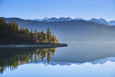 Schneebedeckte Berge spiegeln sich in einem ruhigen See, Walchensee, Bayern, Deutschland - MRF02446