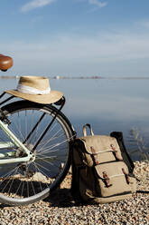 Sonnenhut auf dem Fahrrad mit Rucksack gegen den Himmel an einem sonnigen Tag im Ebro-Delta, Spanien - AFVF08067