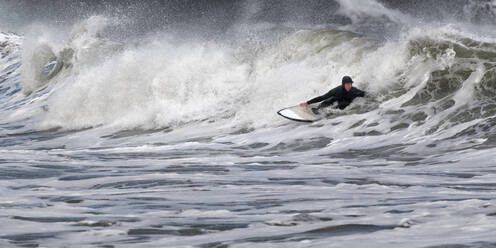 Junger Mann beim Surfen auf dem Meer am Broad Haven South Beach, Wales, UK - ALRF01799