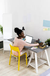 Fashion designer working while sitting at home office - GIOF10795
