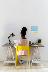 Young businesswoman working while sitting at home office - GIOF10801