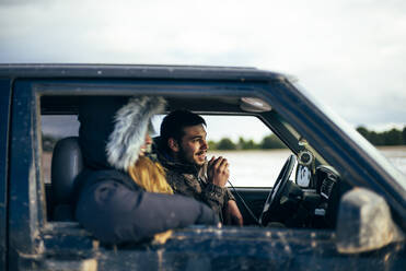 Junger Mann benutzt CB-Funk, während er im Winter mit einer Freundin im Auto unterwegs ist - OCMF02009