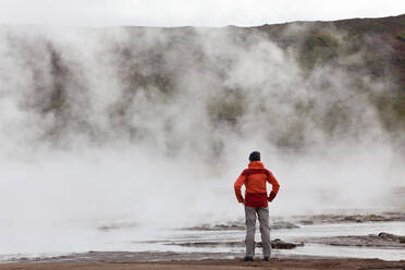 Woman standing by geothermal pools, South West Iceland - MINF15779