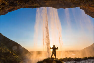 Man behind Seljalandsfoss Waterfall, South Iceland, Iceland - MINF15783