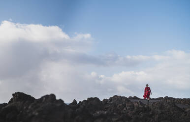 Frau geht auf der Straße gegen die Wolke bei Los Hervideros, Lanzarote, Spanien - SNF00972