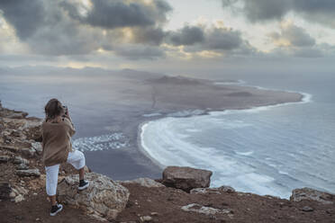Tourist looking at Famara view while standing on mountain at Lanzarote, Spain - SNF00984