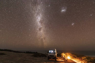 Milky Way over lone woman camping in Nullarbor National Park at night - FOF11989