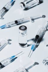 Syringes around COVID-19 vaccine vial on white background - FSIF05595