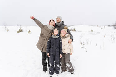 Die Familie genießt den gemeinsamen Urlaub in einer verschneiten Landschaft - EYAF01481