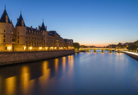 Frankreich, Ile-de-France, Paris, Conciergerie und Seine-Kanal in der Abenddämmerung mit Pont Neuf im Hintergrund - AHF00266