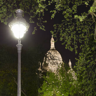 Frankreich, Ile-de-France, Paris, Herz-Jesu-Basilika in Paris bei Nacht mit Straßenlaterne im Vordergrund - AHF00271