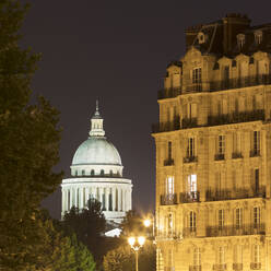 Frankreich, Ile-de-France, Paris, Beleuchtete Kuppel des Pantheon bei Nacht mit Wohngebäude im Vordergrund - AHF00273