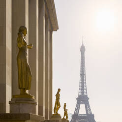 France, Ile-de-France, Paris, Golden statues of Palais de Chaillot with Eiffel Tower in background - AHF00277