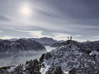 Deutschland, Bayern, Ammergauer Alpen, Teufelstattkopf, Tourist beim Bergwandern an einem Wintertag - RBF08053