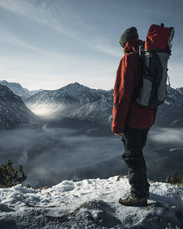 Deutschland, Bayern, Ammergauer Alpen, Teufelstattkopf, Tourist beim Bergwandern an einem Wintertag - RBF08059